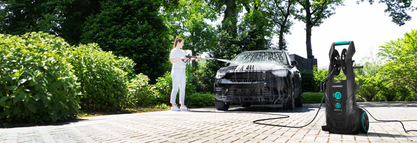 Una donna pulisce l'auto con l'idropulitrice VONROC V25.